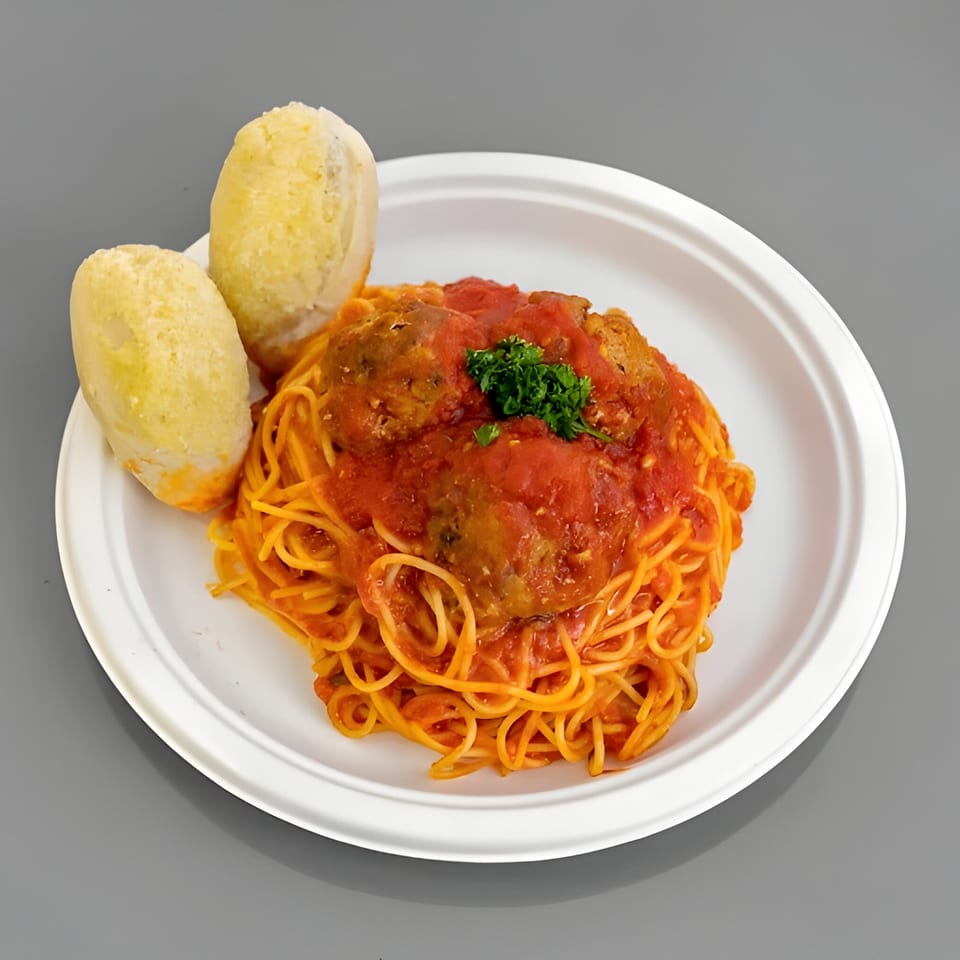 Spaghetti with meatballs and tomato sauce, garnished with parsley, served with two breadsticks.